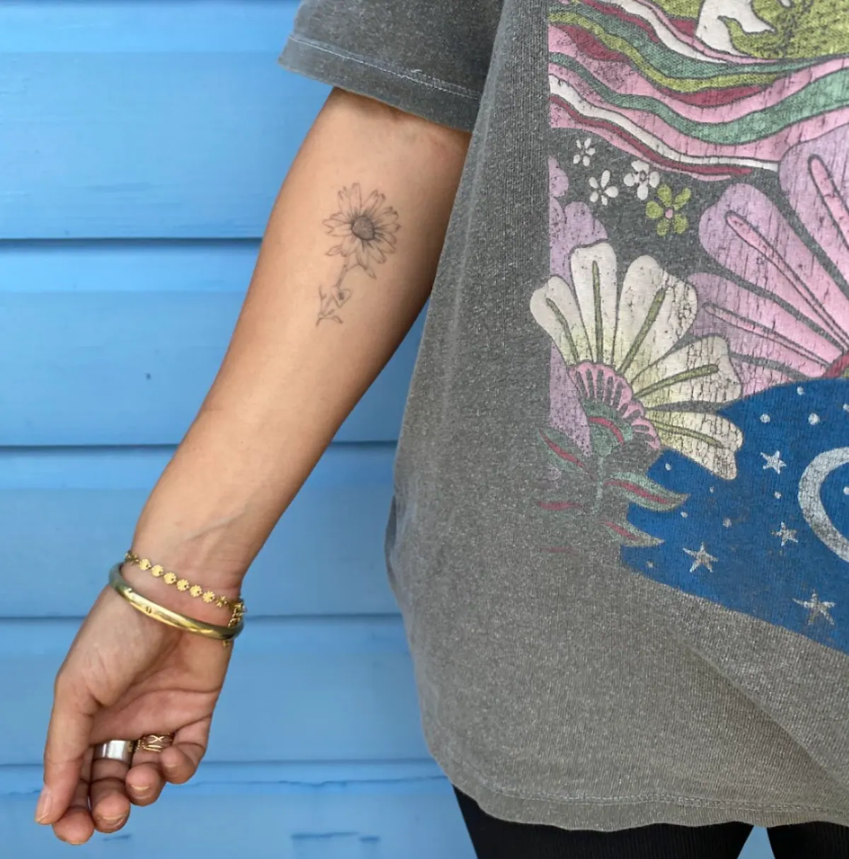Fijne bloem als fineline tattoo op de onderarm